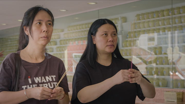 Beng Hock’s sisters Lee Jun (L) and Lee Lan (R), offering prayers at their brother’s shrine