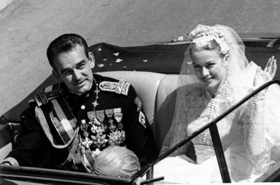 Princess Grace Kelly rides in an open car with Prince Rainier III following their marriage in a religious wedding ceremony in the Monaco Cathedral, 1956. 