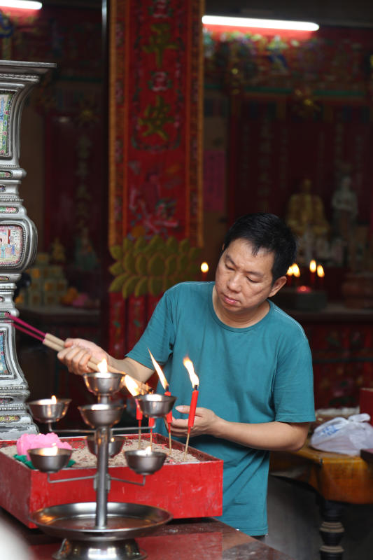 A devotee lighting his incense at a temple near Petaling Street in KL. 
