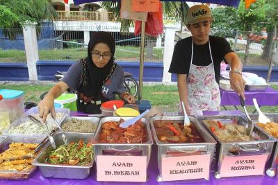 Edzna Suri Ismail sells her mother's authentic Kelantanese cooking with the help of her brother-in-law Muhammad Idil Ilham.