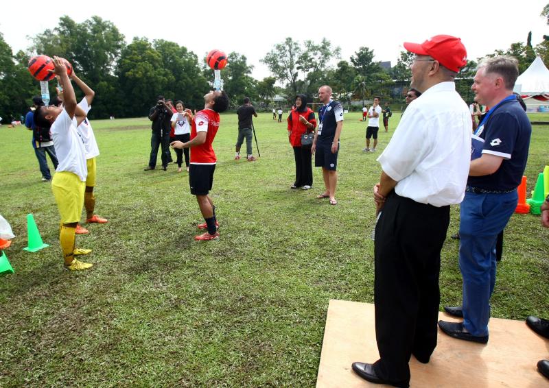 QPR Skills Coach Danny Edwards (third from left) teaching a couple of SMK Seksyen 11 students a few tricks while AirAsia Executive Chairman Dato Kamarudin Meranun (second from right) and QPR Community Trust CEO Andy Evans (right) look on.