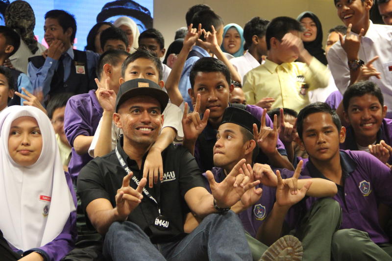 Rapper with a cause: Altimet taking photos with some of the heading-impaired students at an event where he taught them how to sign the lyrics to his latest song, Aku Tahu.