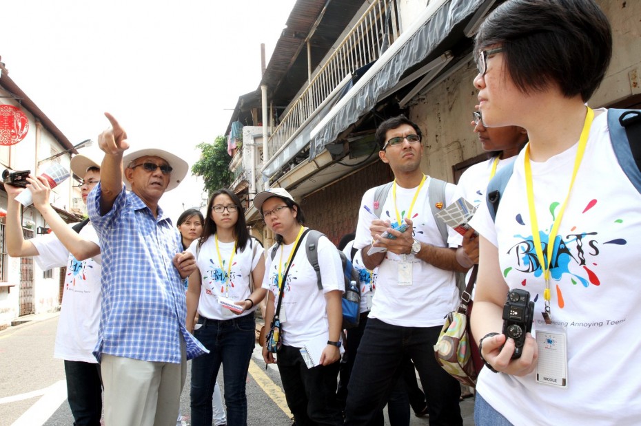 Malacca heritage enthusiast Colin Goh, 68, (second from left) giving the BRATs a tour of the historic Heeran Street, where history lies hidden in every corner.