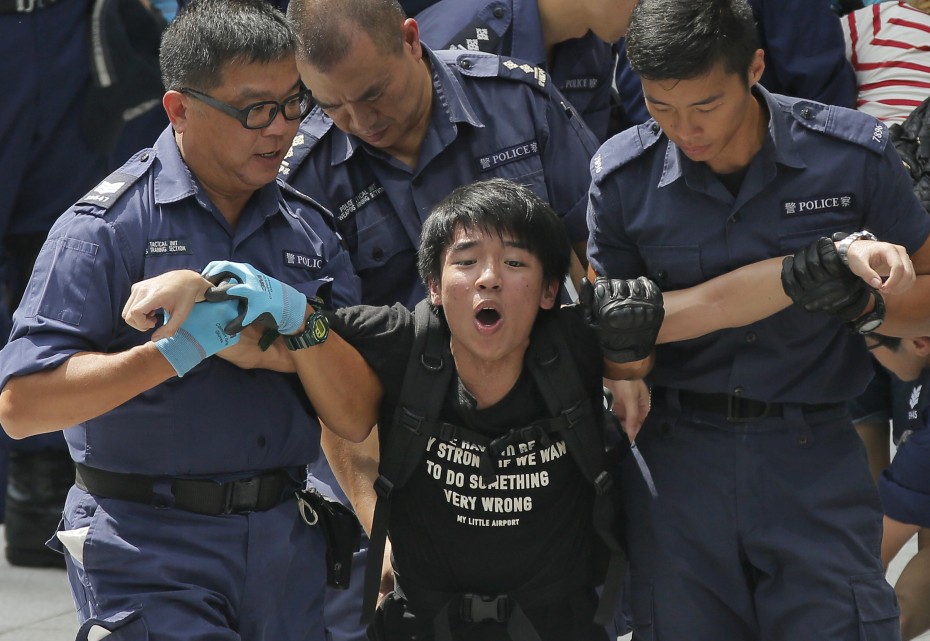 Police removing a student from the government headquarters in Hong Kong after a large number of student protesters stormed the compound.