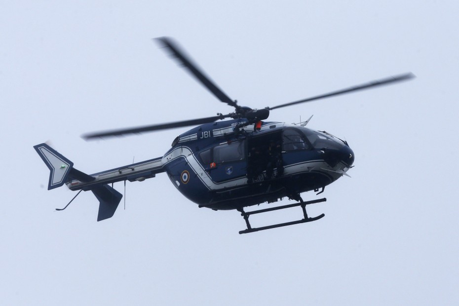 A helicopter flying over the building where the suspects are. -- Photo by EPA