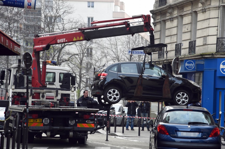 This picture, which was taken yesterday, shows a truck towing the car believed to have been used as the escape vehicle by three gunmen who attacked the office of French satirical newspaper, Charlie Hebdo. - Photo by AFP.