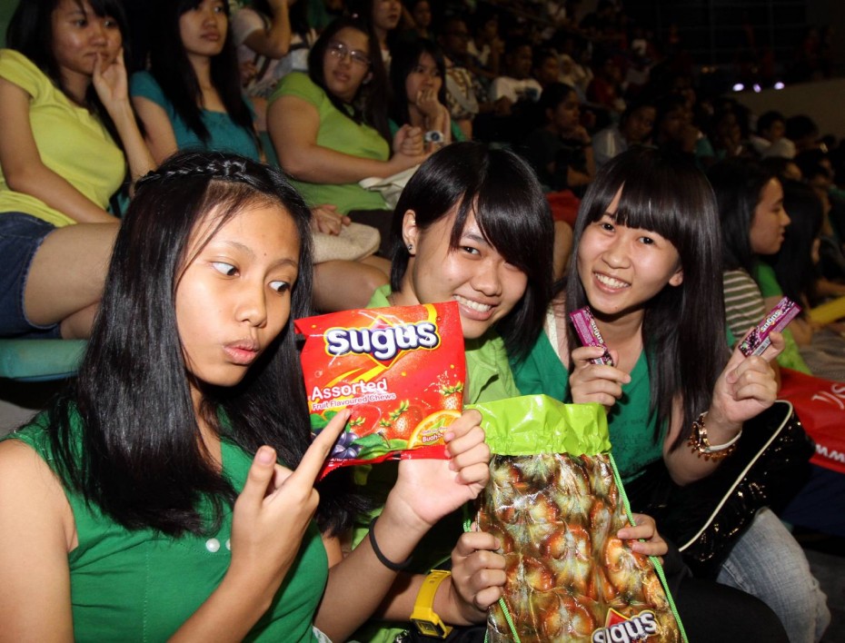 Supporters (left to right) Kathy Chong, Fong Pei Teng and Tan Liang Li enjoying their free goodie bag from Cheer 2012 cosponsors Sugus.