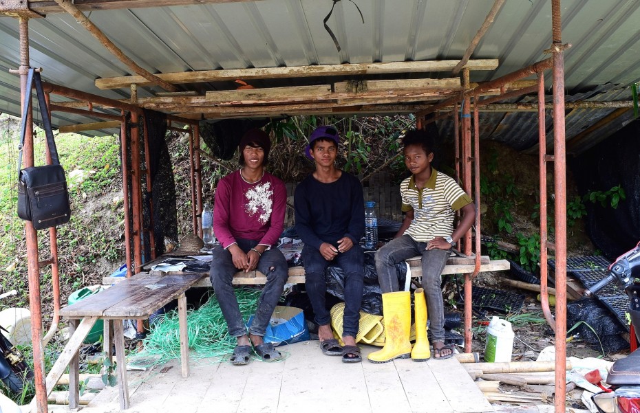 During their break,  (from left) Zofian and his co-workers Atiaz and Ramli rest under a shed. 