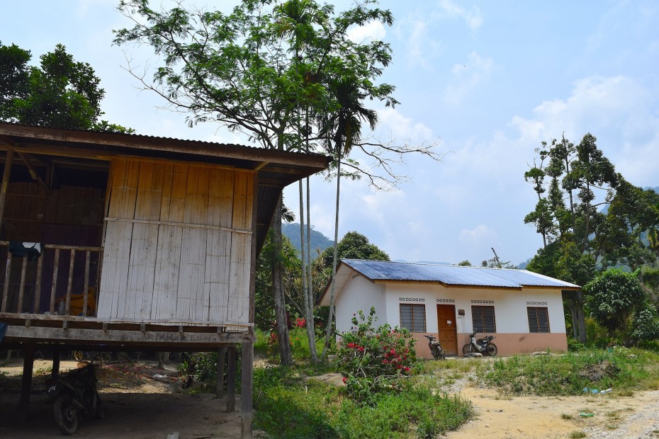 The orang asli prefer to live in their own homes (left) despite government's efforts of building brick houses for them.
