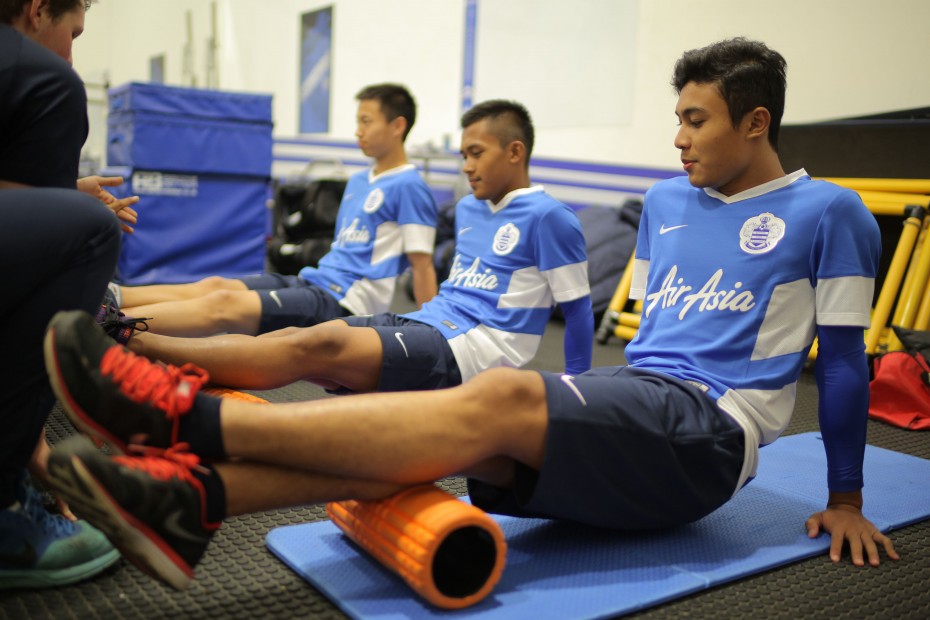 Like all football players, the boys did some strength and conditioning activities during their warm up sessions. Here, they are using the foam rollers to relieve and restore their calf muscles. Photo: AirAsia 
