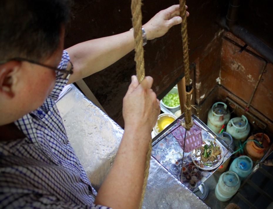 David Chiang demonstrates how the workers at Restoran Hua Mui use the pulley system to bring food up from the kitchen to the second floor.According to David, this system has been around since day one.